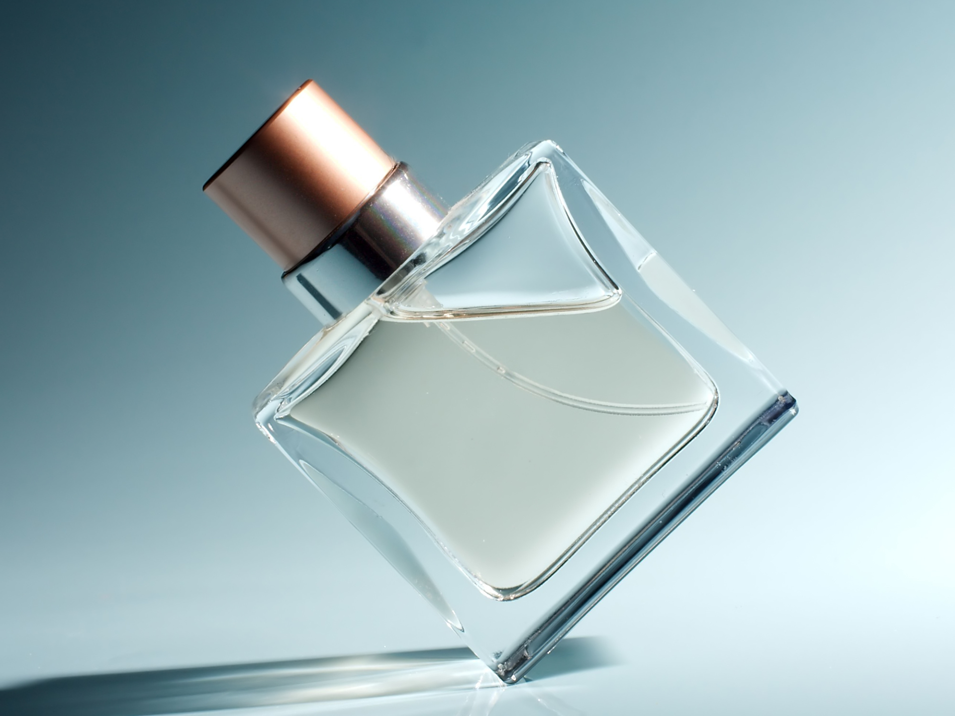 butelka perfum na szaro-niebieskim tle